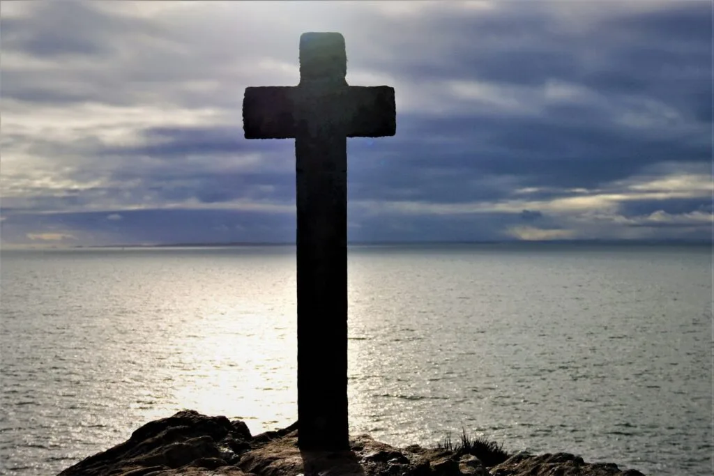 13 - Croix de lumière – Silhouette d'une croix face à l'océan